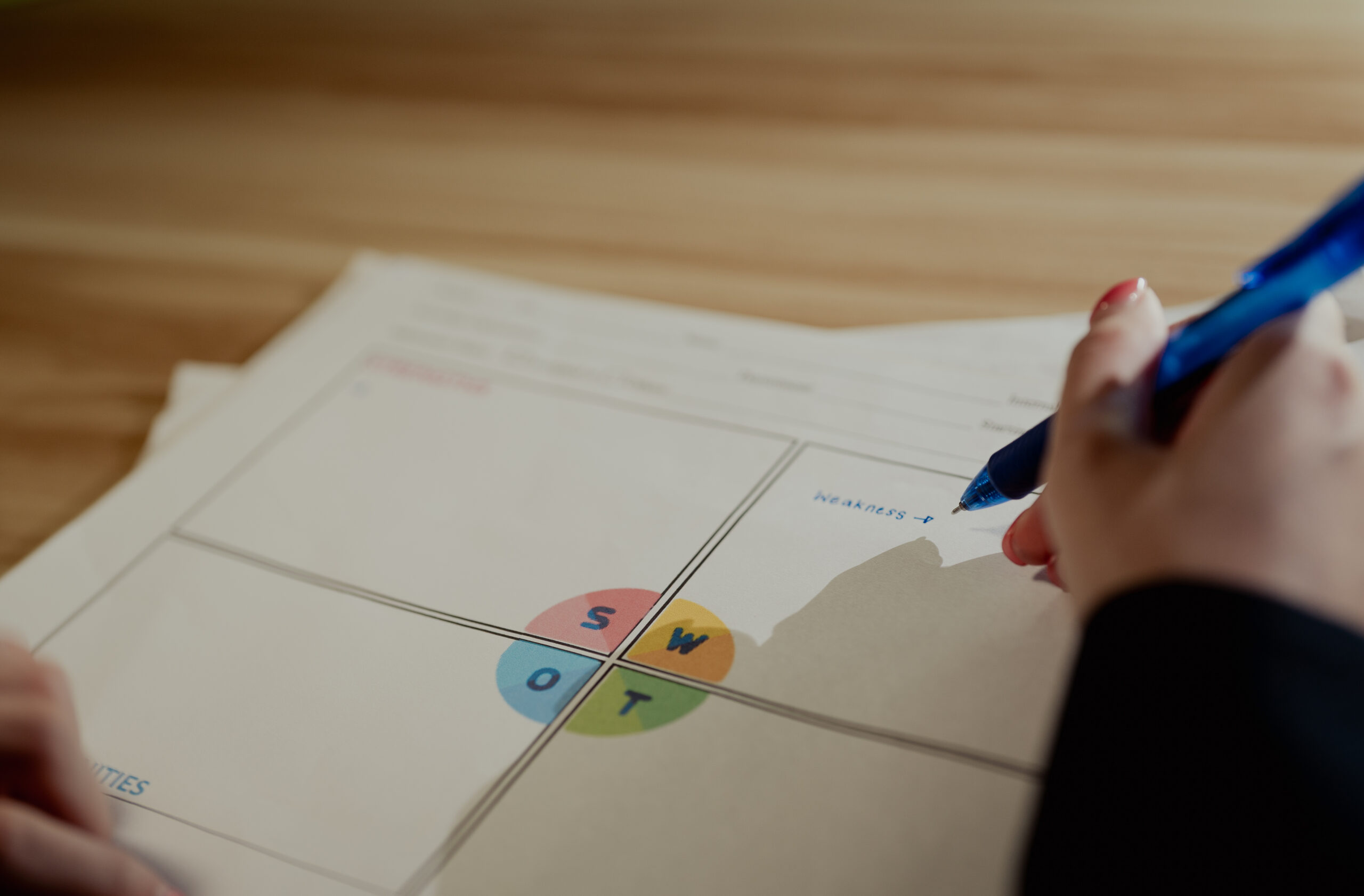 Somebody filling out a swot analysis on paper