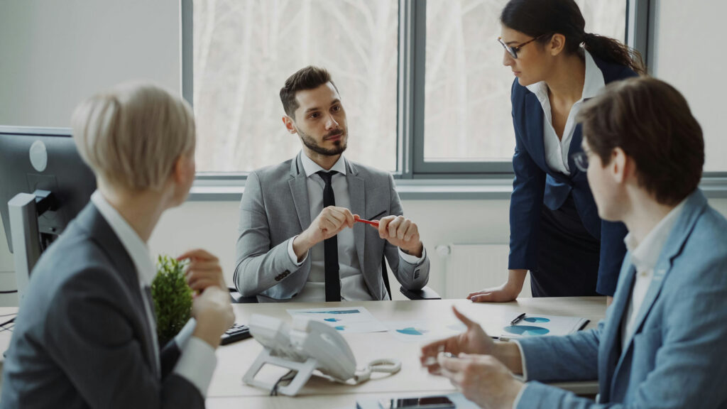 Leadership team discussing documents around a meeting table