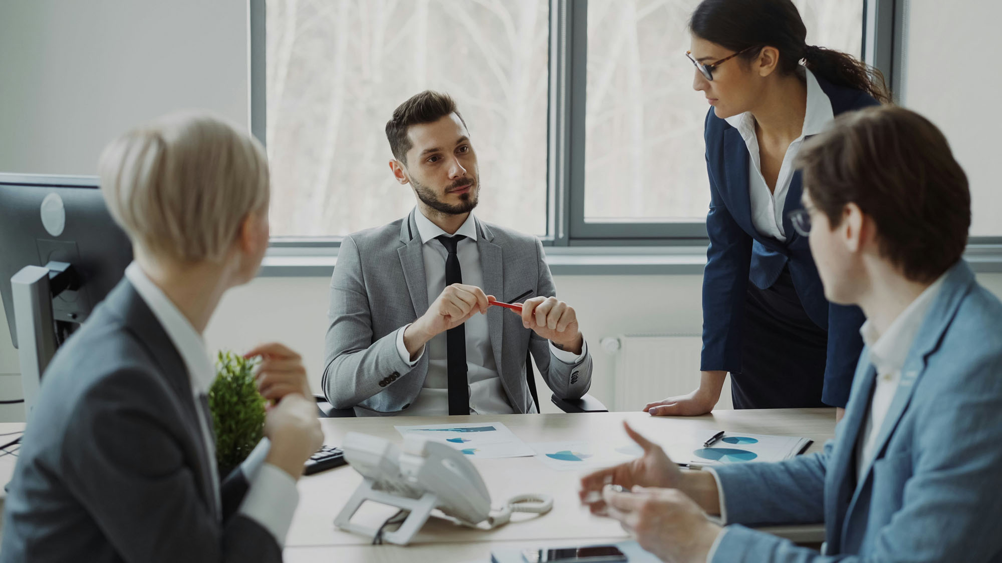 Leadership team discussing documents around a meeting table