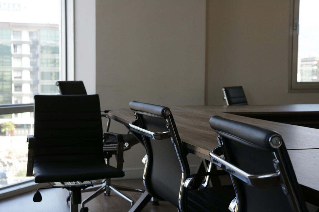 Empty conference room with unoccupied chairs around a meeting table