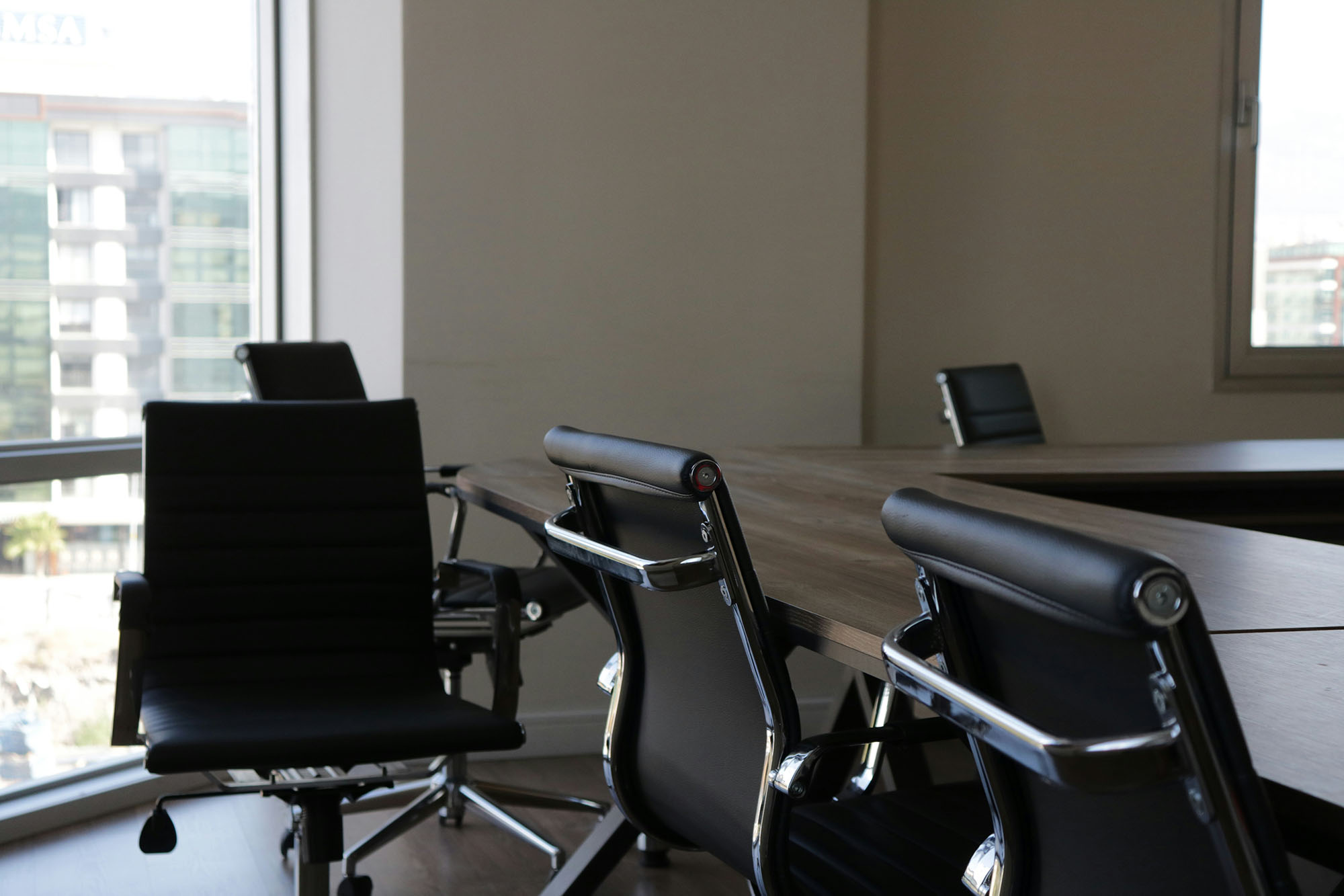 Empty conference room with unoccupied chairs around a meeting table